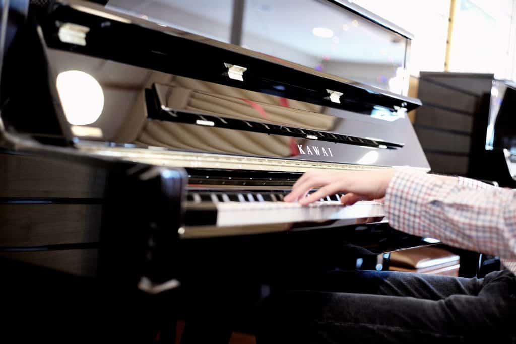 Person playing black Kawai Piano